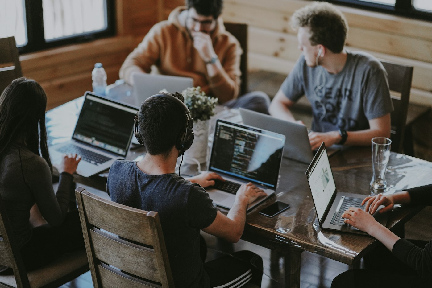 People working together on laptops around a wooden table